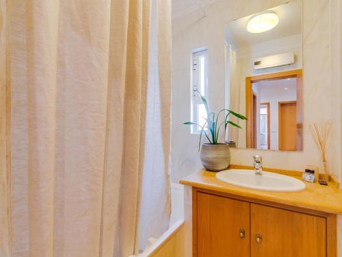 een badkamer met een wastafel en een douchegordijn bij AL - Quarteira Terrace Penthouse in Quarteira