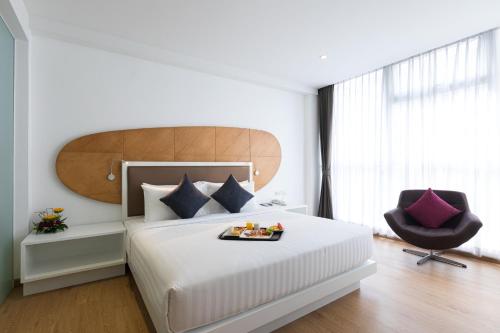 Un dormitorio con una cama con una bandeja de comida. en Hotel Icon Bangkok Sukhumvit 2, en Bangkok