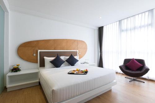 a bedroom with a bed with a tray of food on it at Hotel Icon Bangkok Sukhumvit 2 in Bangkok