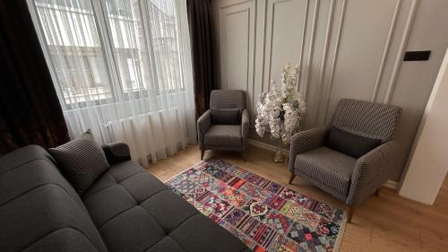 a living room with a couch and two chairs and a rug at KELES HOME in Trabzon