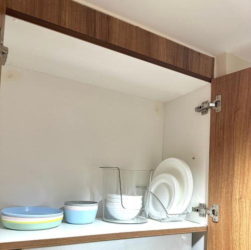 a cabinet with bowls and plates on a shelf at Casa Abigail Shore 3 in Manila