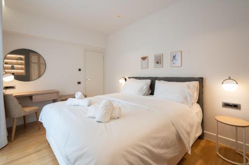 a bedroom with a large white bed and a desk at Acropolis Luxury Penthouses with Majestic Views in Athens