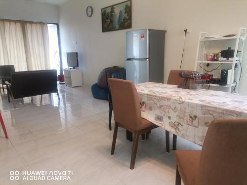 eine Küche und ein Esszimmer mit einem Tisch und einem Kühlschrank in der Unterkunft EBH guesthouse in Malakka