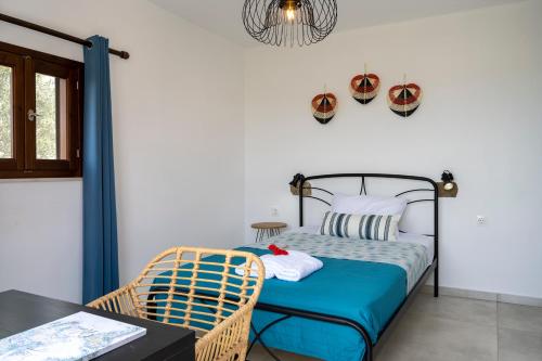 巴勒卡斯寵隆的住宿－Kalithea Nest，一间卧室配有一张带蓝色床单的床和一张桌子。