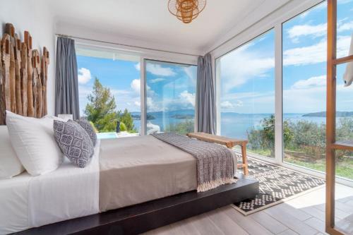 a bedroom with a bed and large glass windows at Indigo Boutique Home in Skiathos Town