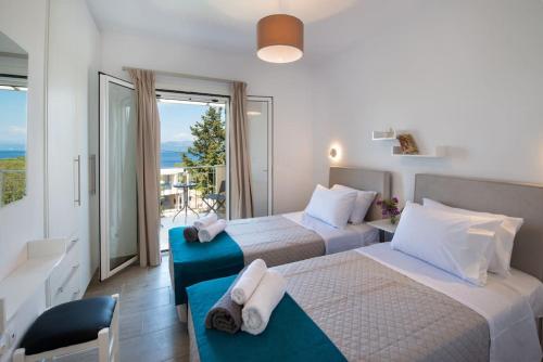 a hotel room with two beds and a balcony at A Casa D' Irene Gaios Paxos in Gaios