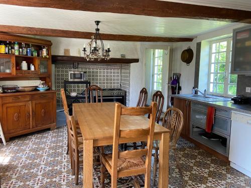 une cuisine avec une table en bois et une salle à manger dans l'établissement Maison de Campagne Baie de Somme 17 couchages, à Tours-en-Vimeu