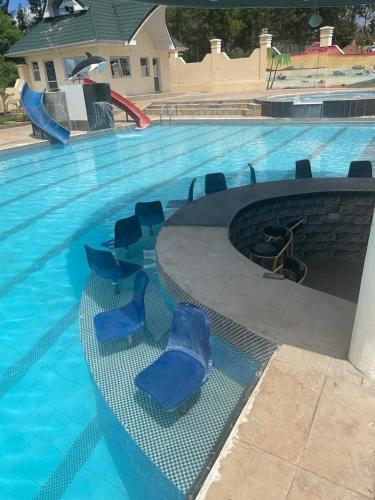a pool with blue chairs in a swimming pool at SILVER SLOPES RESORT AND SPA in Kagio