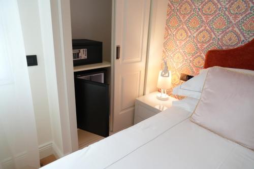 a small bedroom with a white bed and a lamp at Jolly Charme Suite in Messina