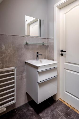 a bathroom with a white sink and a mirror at Altstadt Apartments in Friedrichstadt