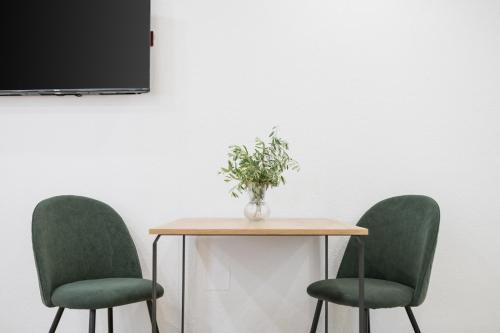 a table with two chairs and a vase of flowers on it at Hotel Maslina in Seget