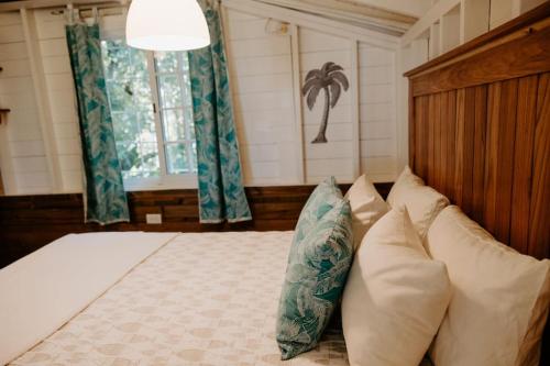 a bedroom with a bed with pillows and a window at CoconutTree Bungalow of Villa Paraiso / Beachfront in Big Creek