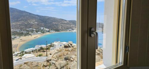 una ventana con vistas a la playa en Almyriki, en Mylopotas