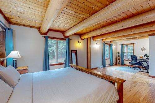 una camera con un grande letto in una stanza con soffitti in legno di Lakeview Chalet a Christina