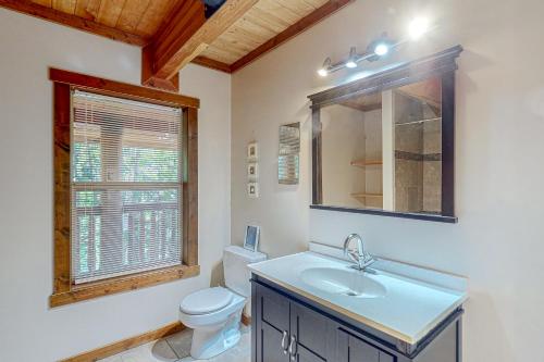 bagno con lavandino, servizi igienici e finestra di Lakeview Chalet a Christina