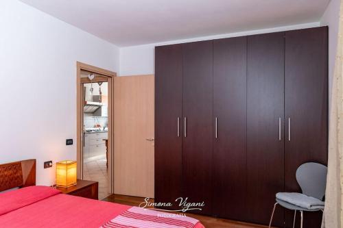 a bedroom with a red bed and a large cabinet at Il Giardino di Laura in Costa Volpino