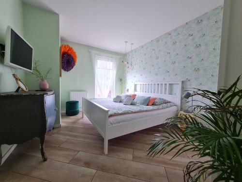 1 dormitorio con 1 cama y TV. en Apartament Sun House z prywatną SAUNĄ KOMINKIEM i widokiem na SKRZYCZNE en Szczyrk