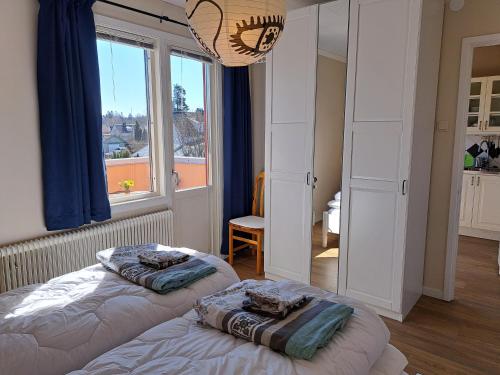 - 2 lits dans une chambre avec une grande fenêtre dans l'établissement Central och ljus 3-rumslägenhet i Älmhult, à Älmhult