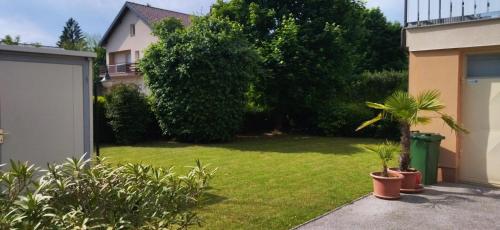 a yard with green grass and trees and a house at Apartmani Horvat - Varaždinske Toplice in Varaždinske Toplice