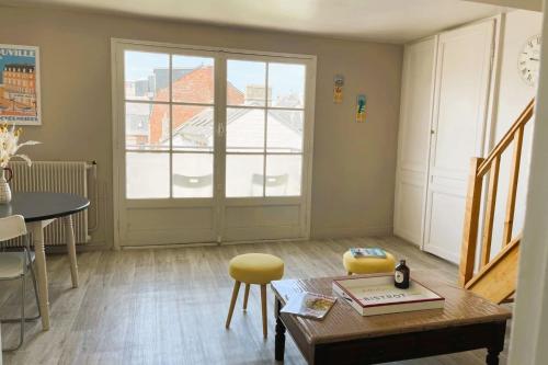 - un salon avec une table et une fenêtre dans l'établissement luminous apartment in the heart of trouville, à Trouville-sur-Mer