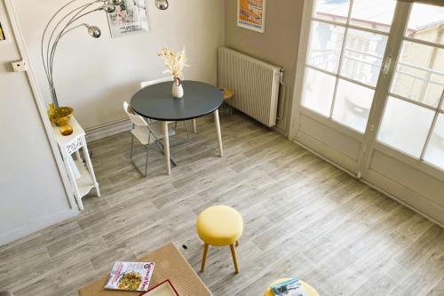 une salle à manger avec une table et une chaise jaune dans l'établissement luminous apartment in the heart of trouville, à Trouville-sur-Mer