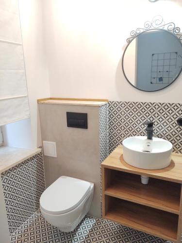 a bathroom with a toilet and a sink and a mirror at Apartment in Center in Kraków