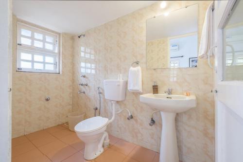 La salle de bains est pourvue de toilettes et d'un lavabo. dans l'établissement Casa Legend Economy, Calangute Goa, à Candolim