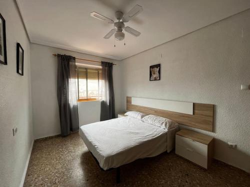 - une chambre avec un lit et un ventilateur de plafond dans l'établissement Amplio y luminoso apartamento, à Sagonte
