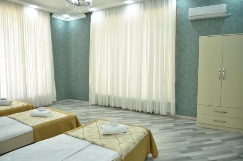 een hotelkamer met 2 bedden en een dressoir bij Foothills Villa in Gabala