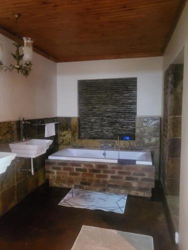 a bathroom with two sinks and a bath tub at The Vine Guest House Potchefstroom in Potchefstroom