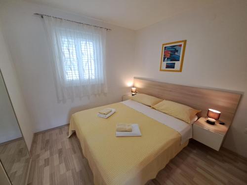 a bedroom with a bed with two towels on it at Apartments Fran I in Baška