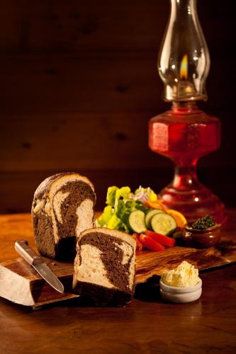 a cutting board with a loaf of bread and vegetables at Bohemian Breeze in Bald Knob