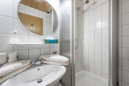 a white bathroom with a sink and a shower at Landhaus Edelweiss in Sankt Leonhard im Pitztal