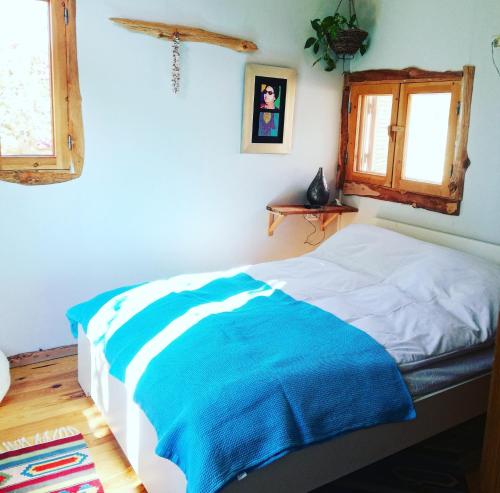 ein Schlafzimmer mit einem Bett mit einer blauen Decke in der Unterkunft Barefoot by Barefoot in Tunis in ‘Izbat an Nāmūs