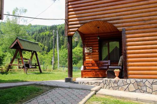 a wooden cabin with a porch and a gazebo at Cottage "Kliverent" in Yaremche
