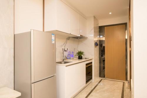 uma cozinha com um frigorífico e um lavatório em Shengang Executive Apartment - Baoan International Airport Bihaiwan Subway Station em Bao'an