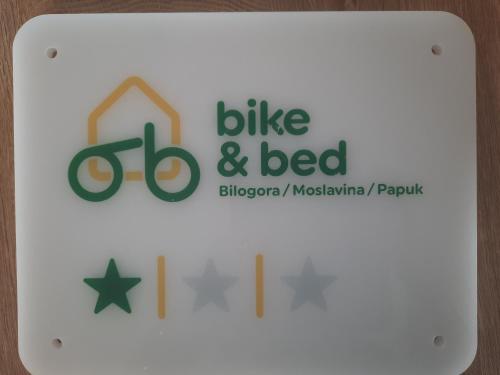 a white sign with the bike and bed logo on it at Holiday&wellness house Grofica in Daruvar
