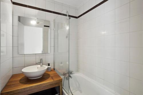 ein Badezimmer mit einem Waschbecken, einem Spiegel und einer Badewanne in der Unterkunft Le Glatigny- Chesnay in Le Chesnay