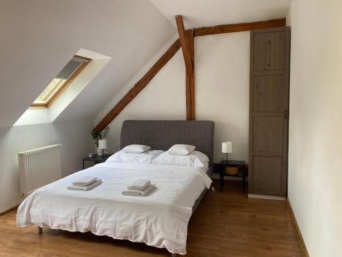 1 dormitorio con 1 cama blanca en el ático en Sunny Attic Apartment, en Zvolen