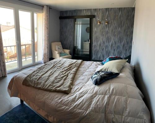 ein Schlafzimmer mit einem großen Bett und einem großen Fenster in der Unterkunft Aux portes des iles in Saint-Just