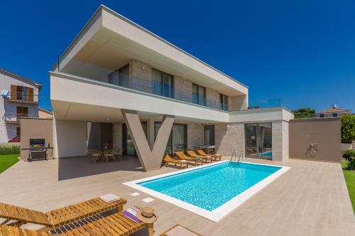 a villa with a swimming pool and a house at Villa VISTA with private pool and sauna in Linardići