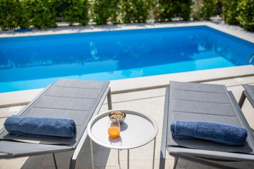 a table and two chairs next to a swimming pool at Villa Bella in Klimno