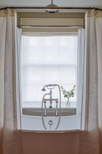 a window with a sink in front of a curtain at Henrys Townhouse Marylebone, London in London
