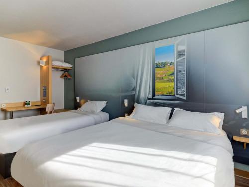 モンチャニンにあるB&B HOTEL Le Creusot Montchaninのベッド2台とデスクが備わるホテルルームです。
