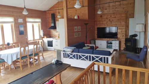 a living room with a couch and a dining room at Spacious house by the Hardangerfjord 