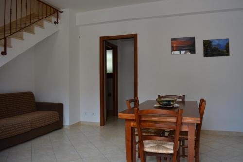 ein Wohnzimmer mit einem Tisch, Stühlen und einem Sofa in der Unterkunft Vacanze Morfino in Castelluzzo