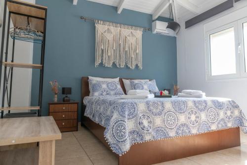 um quarto com uma cama com uma parede azul em Tsitsanis Home em Tympáki