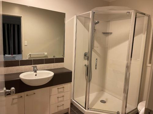 y baño con ducha y lavamanos. en Ruth's House Master room with Private shower and toilet en Auckland