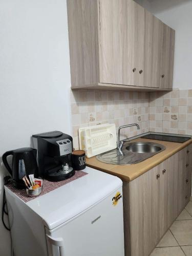 a small kitchen with a sink and a microwave at Stavroula's House in Skiathos Town