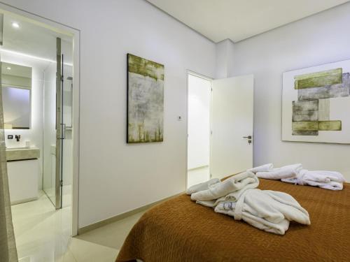 ein Schlafzimmer mit einem Bett und ein Badezimmer mit einem Waschbecken in der Unterkunft Villa Benahavis in Benahavís